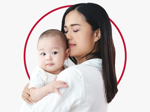 Woman holding baby in her arms happy after Canesten diaper rash treatment